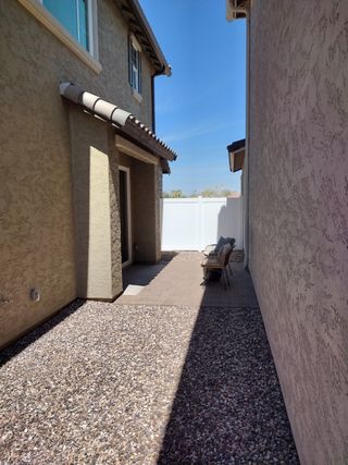 Street view A charming beige stucco home with a cozy patio area, perfect for relaxation, in Hawes Crossing: Discovery by Lennar (Mesa, AZ).