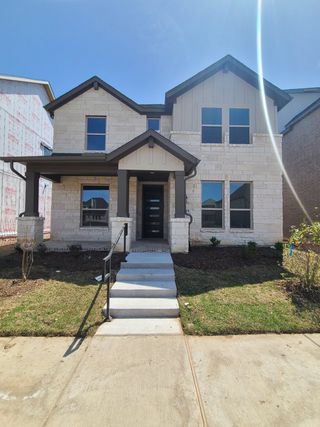 A modern stone-accented home with a cozy porch in Cross Creek Meadows 60s by Taylor Morrison (Celina, TX).