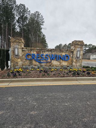 A scenic entrance to Cresswind Georgia at Twin Lakes by Kolter Homes (Hoschton, GA), featuring a stone sign with colorful landscaping.