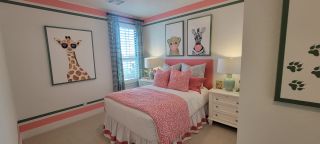 Model Home A playful bedroom with animal artwork, pink bedding, and stylish lamps, perfect for a lively and cozy atmosphere.