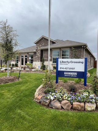 A charming brick home with lush landscaping in Liberty Crossing by D.R. Horton, Royse City, TX.
