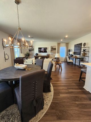Model Home An elegant open-concept living area with chic lighting, cozy seating, and stylish wood flooring.