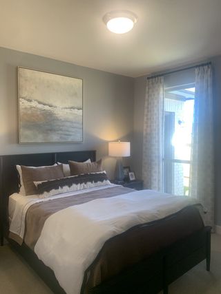 A cozy bedroom featuring a modern bed, abstract artwork, and soft natural light filtering through elegant curtains.