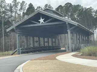 Street view A rustic covered bridge entrance in Horizons at Summers Corner by Lennar, enhancing the charm of Summerville, SC.