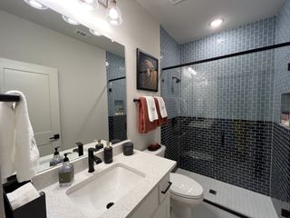 A stylish en-suite bathroom featuring a double vanity, elegant lighting, and modern finishes in Solterra by David Weekley Homes (Mesquite, TX).