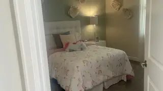 A cozy bedroom featuring a unicorn-themed duvet, soft lighting, and decorative wall flowers. Perfect for a child's dreamy retreat.