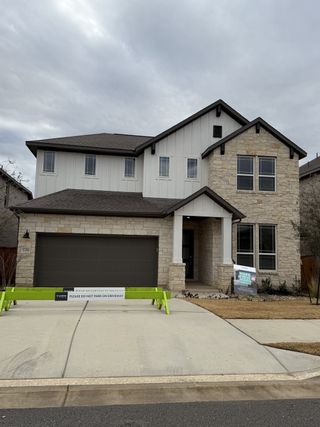 Street view A modern stone and stucco home in Park Collection at Lariat by Tri Pointe Homes (Liberty Hill, TX).