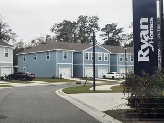 Street view Charming blue homes with white trim and manicured lawns in Sadler Trace by Ryan Homes, Jacksonville, FL.