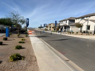Street view Modern homes line a serene street in Wildera – Canyon Series by Landsea Homes, San Tan Valley, AZ, with desert landscaping.