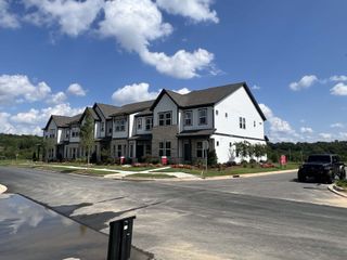 A charming row of modern homes in Ridge at Sugar Creek by Taylor Morrison, set against a blue sky in Indian Land, SC.