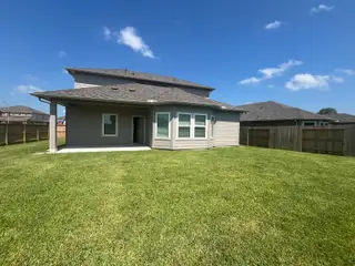 A charming gray home with a spacious backyard in Wall Street Village by Meritage Homes (Richmond, TX).
