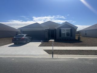 Modern single-story home with a painted exterior, a two-car garage, and a large front entrance.