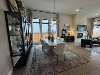 A sophisticated living and dining space with large windows, elegant decor, and a cozy fireplace.