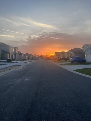 A serene street view at sunset in Marion Ranch: Marion Ranch 60's by Lennar, Ocala, FL, showcasing beautiful homes.