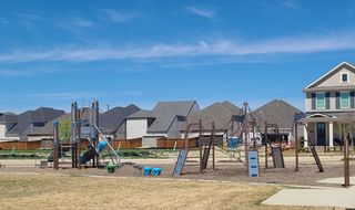 A vibrant playground beside modern homes in Village on Main Street by CB JENI Homes (Frisco, TX).