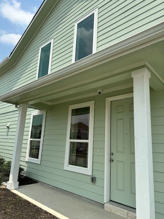 A charming mint-green home with a welcoming porch in Avery Centre by Pacesetter Homes (Round Rock, TX).
