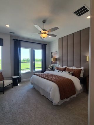 A cozy bedroom featuring a plush bed, elegant headboard, and lots of natural light with scenic views.