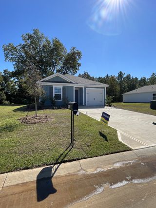 A cozy blue-gray home with a manicured lawn in Center Pointe by D.R. Horton (Santee, SC).