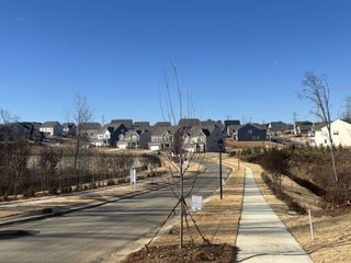 New development in Bryton by Pulte Homes, Huntersville, NC, featuring modern homes along a winding, landscaped street.