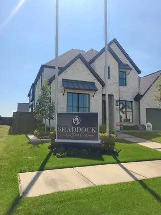 A beautiful contemporary home with a manicured lawn in Estates at Rockhill by Shaddock Homes (Frisco, TX).
