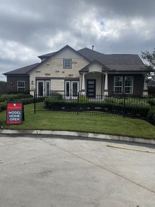 A charming brick home with a modern façade and manicured lawn in Pecan Estates by CastleRock Communities (Crosby, TX).