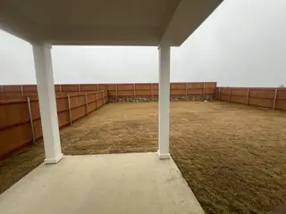 Street view A spacious backyard with a covered patio and wooden privacy fence.