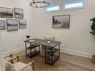 A cozy home office with a rustic desk, elegant wall art, and stylish lighting, creating a serene work environment.