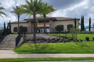 Community Amenities A beautiful stone-accented home with lush landscaping in Ridgeview by Trinity Family Builders (Clermont, FL).