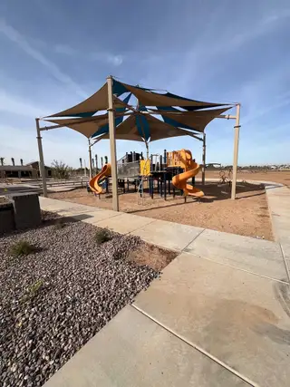 A vibrant playground with slides and shade in North Shore at Acclaim by Fulton Homes (Avondale, AZ).