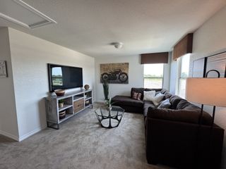 A cozy living room with a plush sectional sofa, modern TV stand, and stylish decor, bathed in natural light.