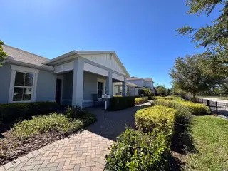 A charming, welcoming entrance with well-maintained landscaping and a porch in Isles of Lake Nona by Pulte Homes (Orlando, FL).