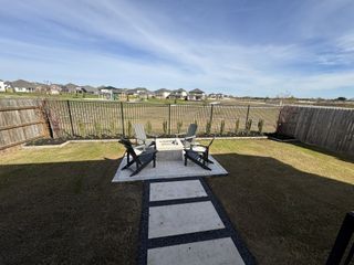 Model Home A serene backyard with a modern patio and cozy seating area, overlooking a peaceful neighborhood.