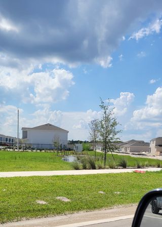A scenic neighborhood view with new homes and vibrant lawns in Westview: Aden South III by Lennar (Kissimmee, FL).
