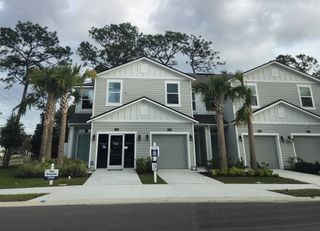Street view A charming gray and white home with a clean driveway and palm trees in Wyndbrook by D.R. Horton (Jacksonville, FL).