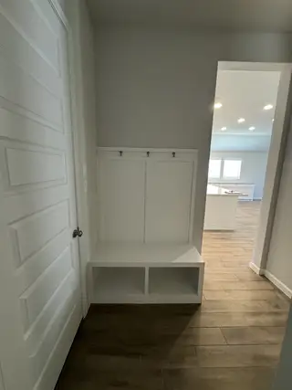 A functional mudroom with a built-in bench, storage cubbies, and coat hooks for a practical and organized entryway.