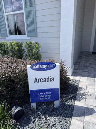 A stylish home exterior with blue shutters and a tidy garden in Sandridge Hills by Mattamy Homes (Green Cove Springs, FL).