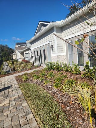 A charming home with a paved walkway and lush landscaping in Irongate by Richmond American Homes (Jacksonville, FL).
