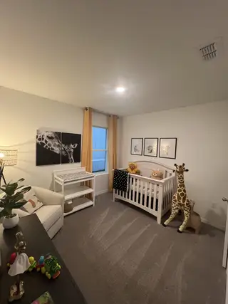 A cozy nursery with a white crib, playful giraffe decor, and soft lighting.