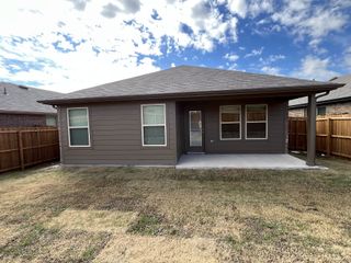 A fenced backyard featuring a covered patio, ideal for outdoor relaxation.