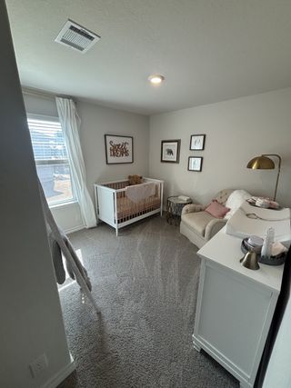 Charming nursery with a cozy crib, plush chair, and soft lighting, perfect for sweet dreams.