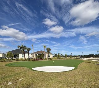Charming homes with a putting green under a vibrant sky in The Timbers at Everlands by Lennar (Palm Bay, FL).