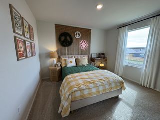 A stylish secondary bedroom with a wooden bed frame, modern artwork, and soft natural light for a cozy ambiance.