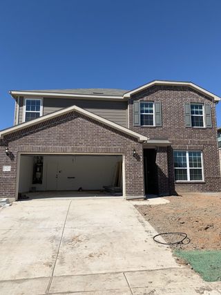 Street view A beautiful brick home with classic windows and a spacious driveway in Lagos by Pulte Homes (Manor, TX).