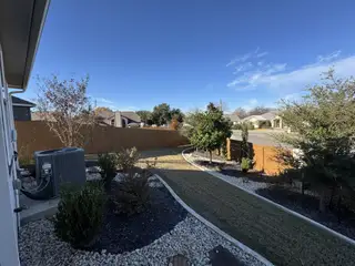 A neatly maintained backyard featuring lush greenery, decorative stone pathways, and a fenced perimeter for added privacy.