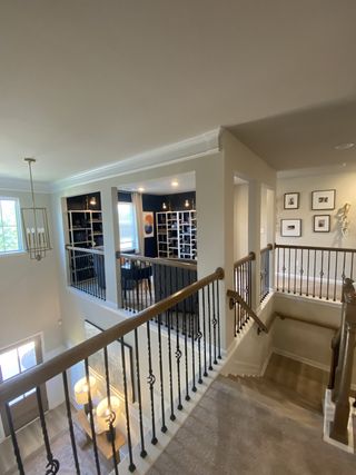 A sophisticated interior with elegant railing, modern art, and ample natural light, offering a chic and inviting ambiance.