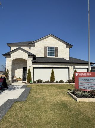 Street view A beautiful model home by Castlerock Communities with a well-manicured lawn and with red signage.