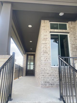 Model Home A modern entrance with a brick facade and sleek railing in Turner's Crossing - Park Collection by Tri Pointe Homes (Austin, TX).