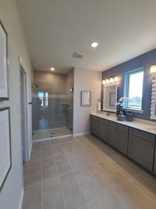 A sleek bathroom with a spacious glass shower, dual vanity, and chic lighting for a modern touch.