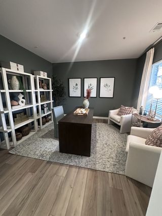 A stylish home office with dark walls, elegant shelving, and comfortable seating, creating a cozy and modern workspace.