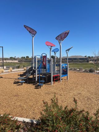 A vibrant playground with modern play structures in Estates at Estrella Crossing by Ashton Woods (Phoenix, AZ).